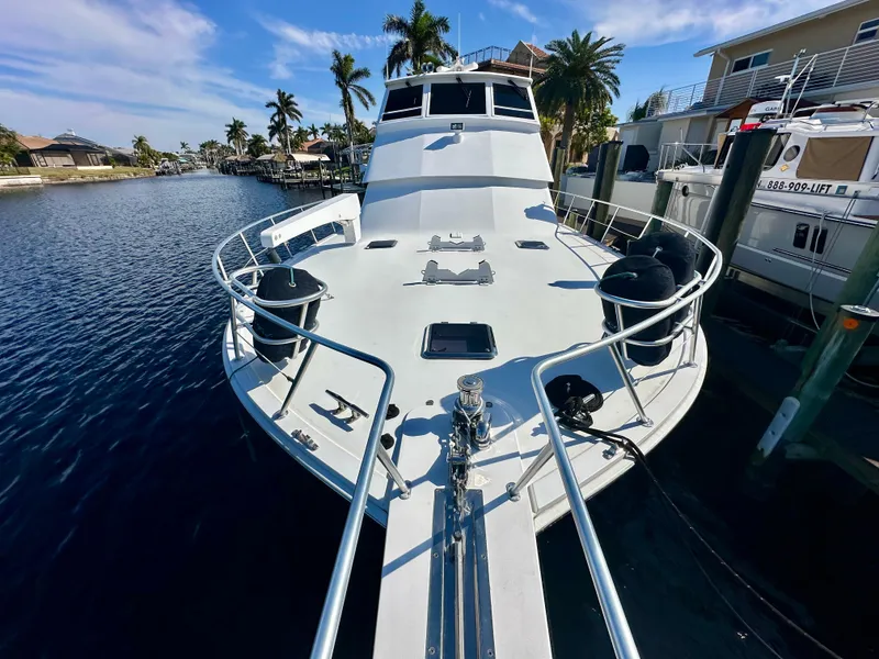 Slide: The Image of 1999 Viking 60 Cockpit Sports Yacht docked in a sunny marina. - 4