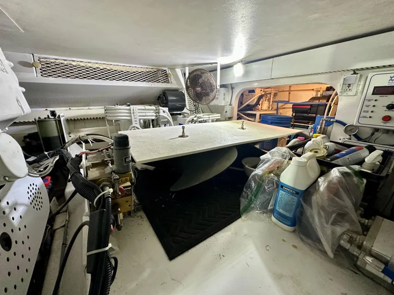 Slide: The Image of Engine room of a 1999 Viking 60 Cockpit Sports Yacht, featuring equipment and storage. - 45