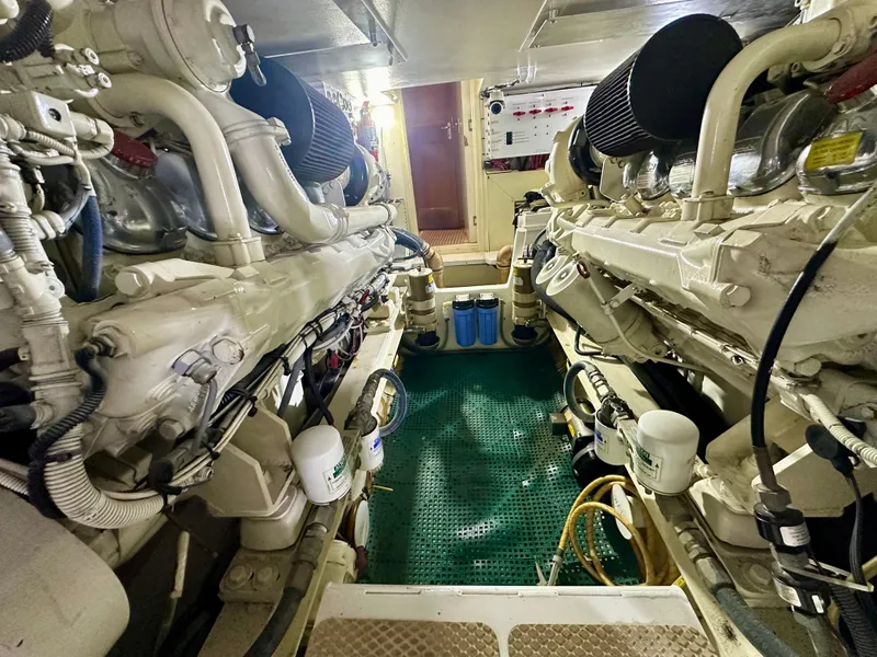Slide: The Image of Engine room of a 1999 Viking 60 Cockpit Sports Yacht, showcasing dual engines. - 48