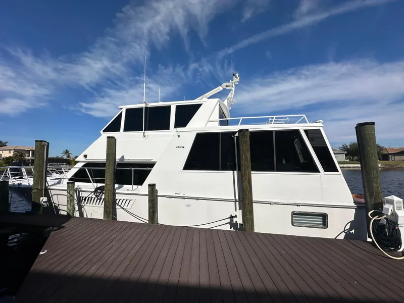 Slide: The Image of 1999 Viking 60 Cockpit Sports Yacht docked under clear blue sky. - 6