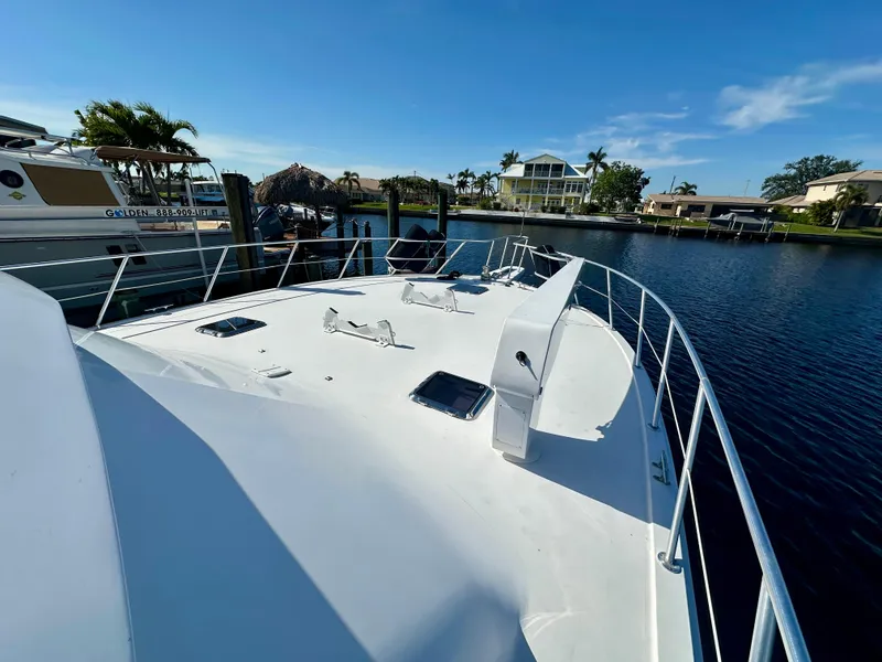 Slide: The Image of 1999 Viking 60 Cockpit Sports Yacht docked in a serene marina setting. - 8