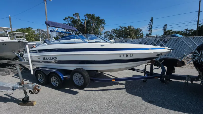Slide: The Image of 2005 Larson LXi 208 boat on trailer in sunny outdoor setting. - 1