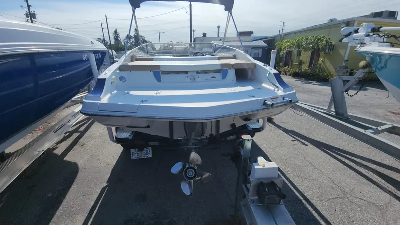 Slide: The Image of 2005 Larson LXi 208 boat, rear view, parked on a trailer in a marina. - 11