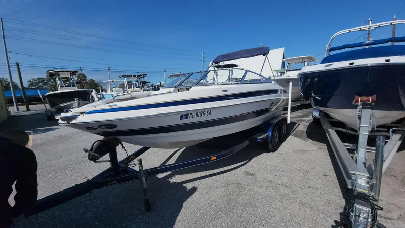 Slide: The Image of 2005 Larson LXi 208 boat on trailer in sunny marina. - 13