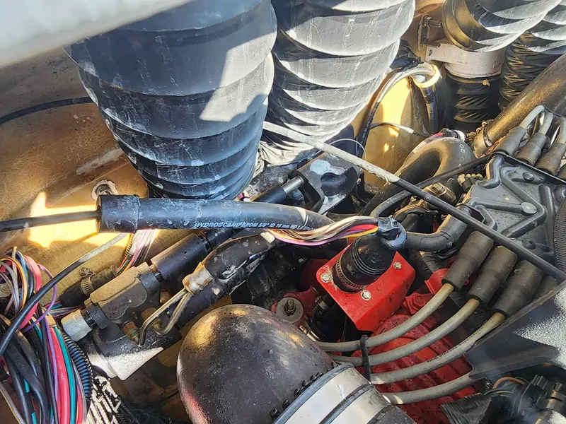 Slide: The Image of Engine components of a 2005 Larson LXi 208 boat, featuring hoses and wiring. - 29