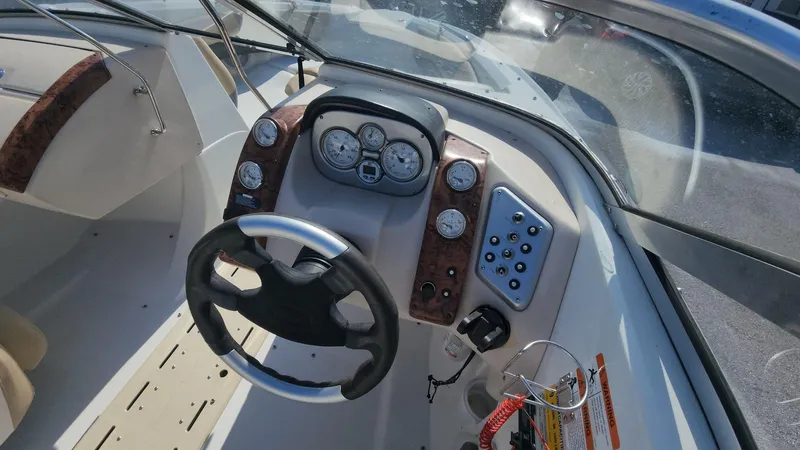 Slide: The Image of 2005 Larson LXi 208 boat dashboard with steering wheel and instrument panel. - 6