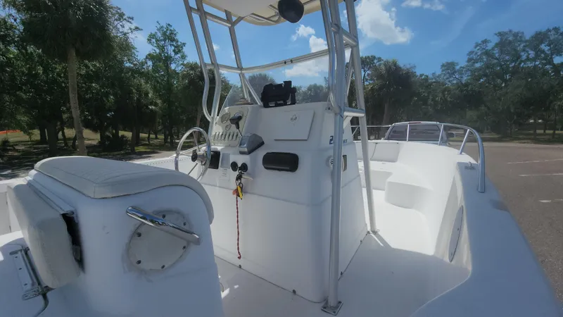 Slide: The Image of 2003 Pro-Line 22 boat interior with steering console, white seating, and clear blue sky. - 15