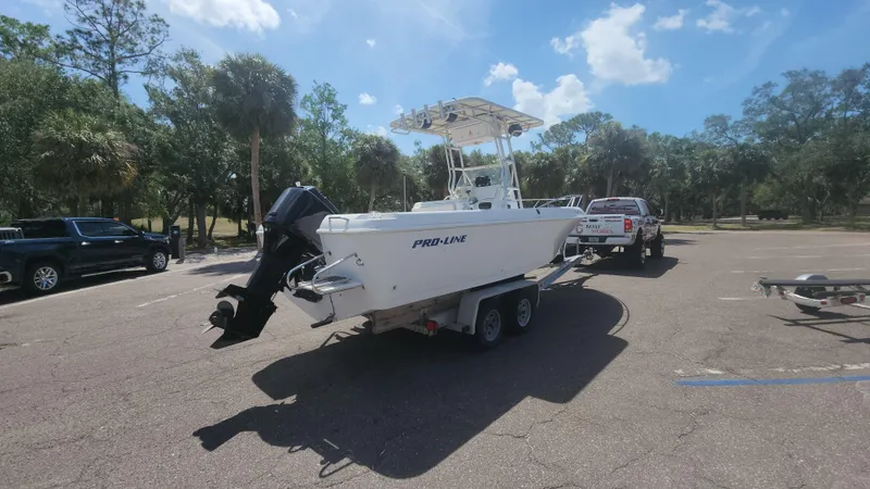 Slide: The Image of 2003 Pro-Line 22 boat on trailer in sunny parking lot with trees. - 20