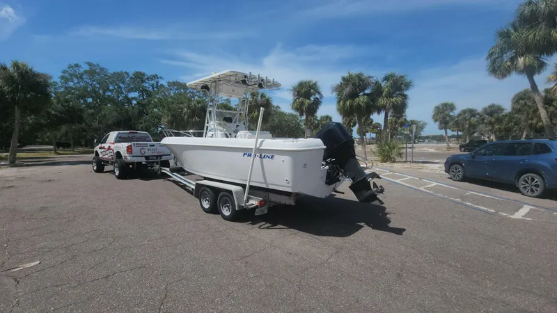 Slide: The Image of 2003 Pro-Line 22 boat on trailer, parked in sunny lot with palm trees. - 28