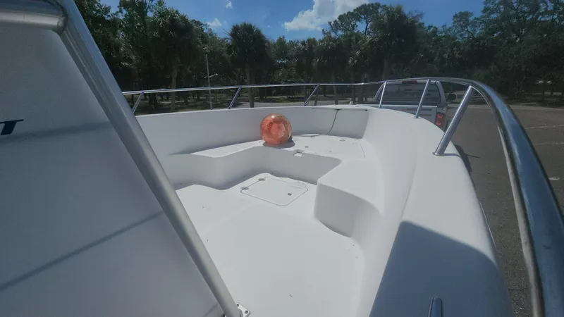 Slide: The Image of 2003 Pro-Line 22 boat deck with railing and orange buoy under clear sky. - 38