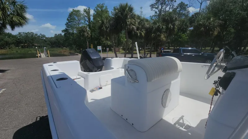 Slide: The Image of 2003 Pro-Line 22 boat with seating, parked near a scenic, tree-lined area. - 42