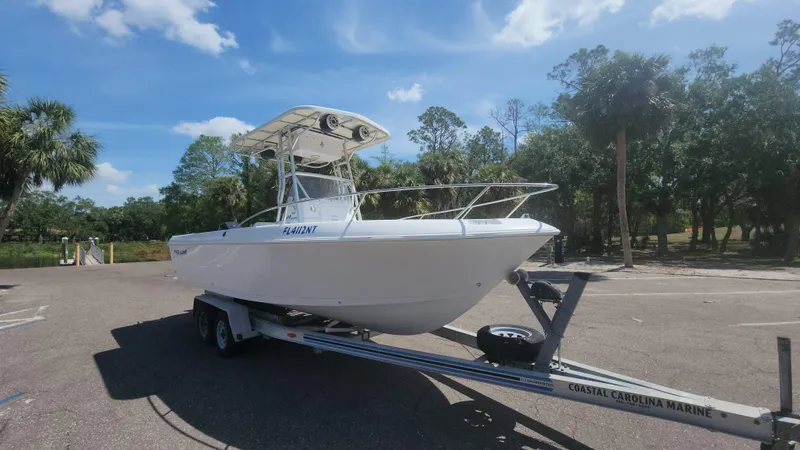 Slide: The Image of 2003 Pro-Line 22 boat on trailer in sunny parking lot with trees. - 5