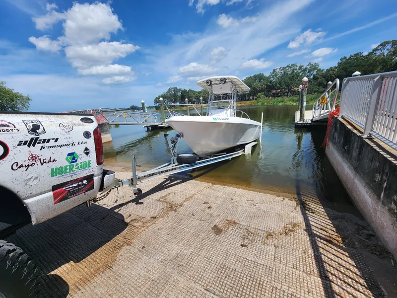 Slide: The Image of 2003 Pro-Line 22 boat being launched from a trailer at a sunny lakeside dock. - 6