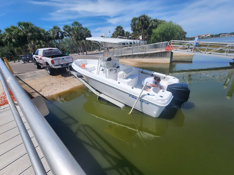 Slide: The Image of 2003 Pro-Line 22 boat being launched from a trailer at a sunny boat ramp. - 7