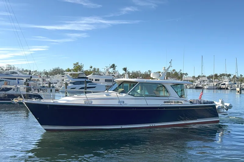 Slide: The Image of 2023 Sabre 43 Salon Express yacht docked in a marina under clear skies. - 0