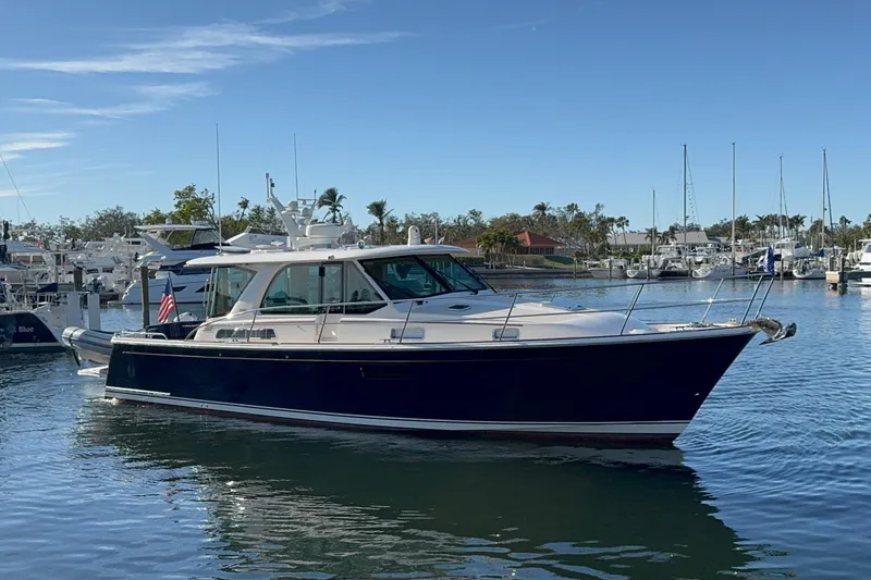 Slide: The Image of 2023 Sabre 43 Salon Express yacht in marina, clear blue sky, calm water. - 1