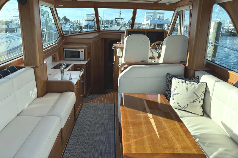 Slide: The Image of 2023 Sabre 43 Salon Express interior with elegant wood finish and plush seating. - 13