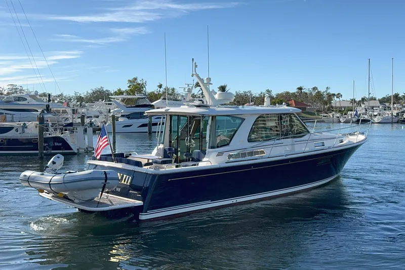 Slide: The Image of 2023 Sabre 43 Salon Express yacht docked in a marina, featuring sleek design and American flag. - 4