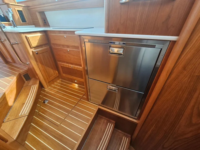 Slide: The Image of 2023 Sabre 43 Salon Express interior with wood cabinetry and stainless steel appliances. - 41