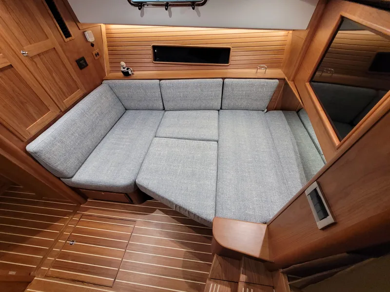 Slide: The Image of 2023 Sabre 43 Salon Express interior with gray L-shaped sofa and wooden paneling. - 48