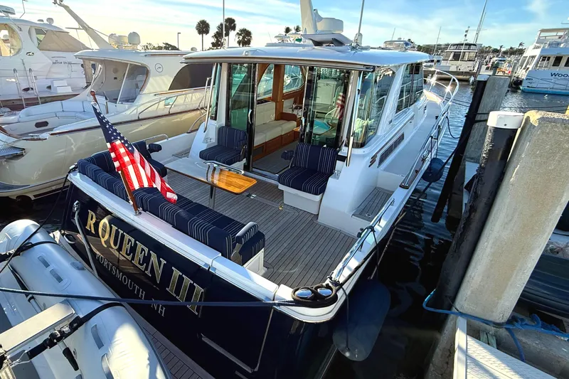 Slide: The Image of 2023 Sabre 43 Salon Express yacht docked, featuring elegant seating and American flag. - 6