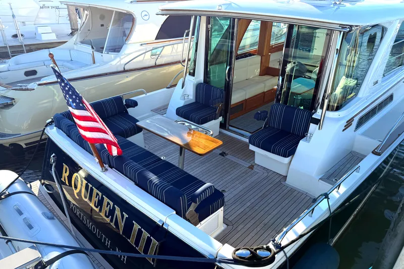 Slide: The Image of 2023 Sabre 43 Salon Express yacht with American flag and elegant seating area. - 8