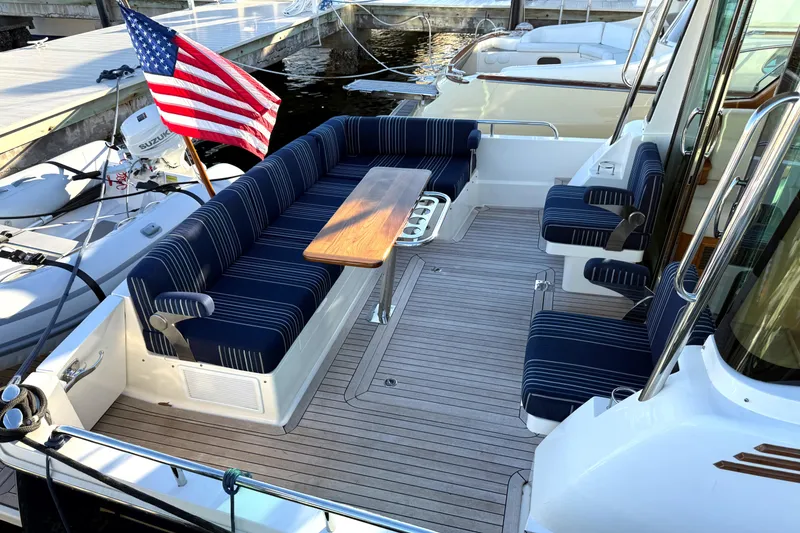 Slide: The Image of 2023 Sabre 43 Salon Express yacht with striped seating and American flag. - 9