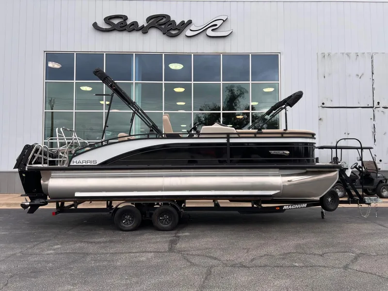 Slide: The Image of 2025 Harris Solstice 230 pontoon boat on trailer outside dealership. - 1