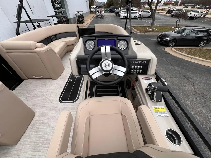 Slide: The Image of 2025 Harris Solstice 230 boat interior with beige seating and modern steering console. - 22