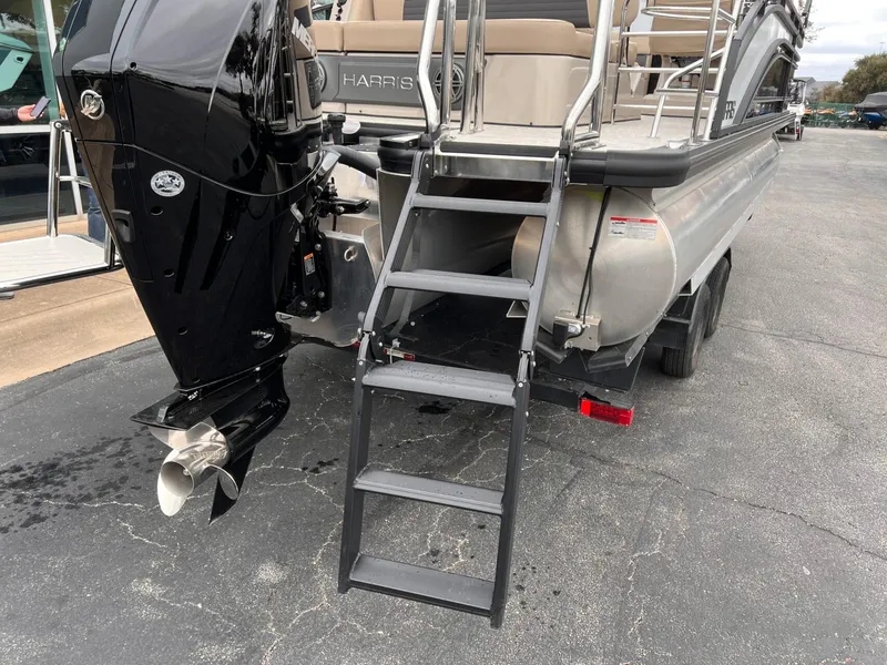 Slide: The Image of 2025 Harris Solstice 230 pontoon boat rear view with motor and boarding ladder. - 6
