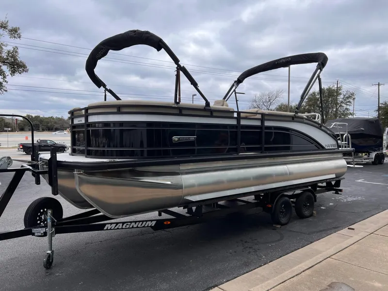 Slide: The Image of 2025 Harris Solstice 230 pontoon boat on trailer, parked outdoors. - 9