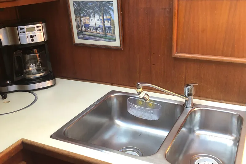 Slide: The Image of 1987 Chris-Craft 426 Catalina kitchen with sink, coffee maker, and wall art. - 10