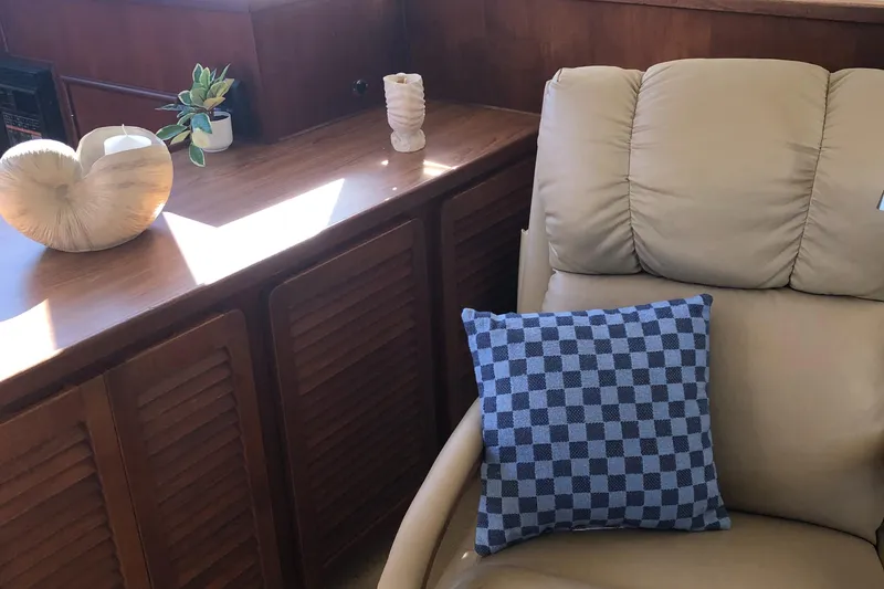 Slide: The Image of Interior of 1987 Chris-Craft 426 Catalina with beige chair and blue checkered pillow. - 11