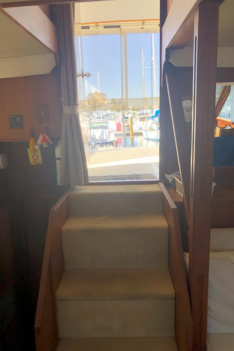 Slide: The Image of Interior view of 1987 Chris-Craft 426 Catalina yacht with stairs leading to deck. - 12