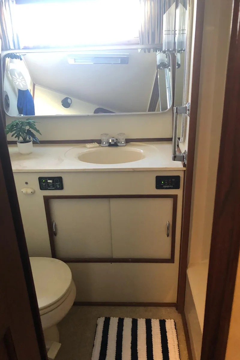 Slide: The Image of 1987 Chris-Craft 426 Catalina bathroom with sink, mirror, and striped rug. - 19