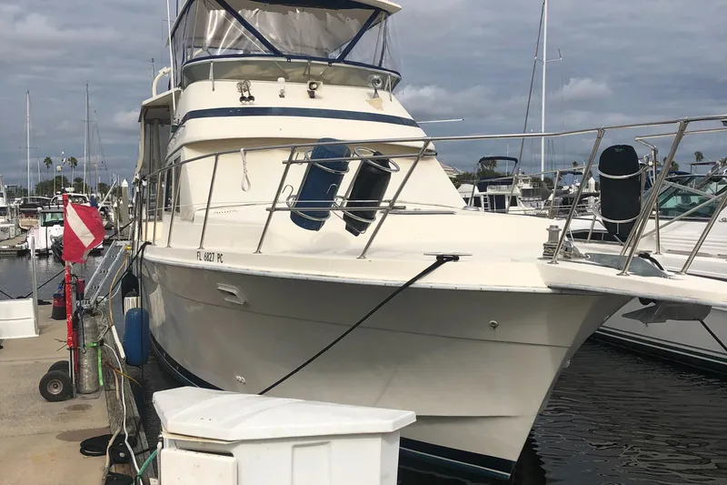 Slide: The Image of 1987 Chris-Craft 426 Catalina yacht docked at marina under cloudy skies. - 2