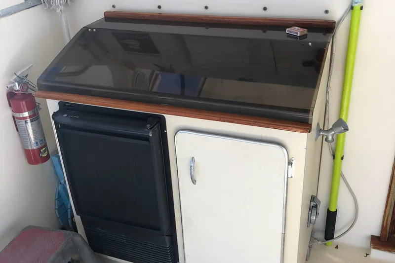 Slide: The Image of 1987 Chris-Craft 426 Catalina interior with fridge, cabinet, and fire extinguisher. - 27