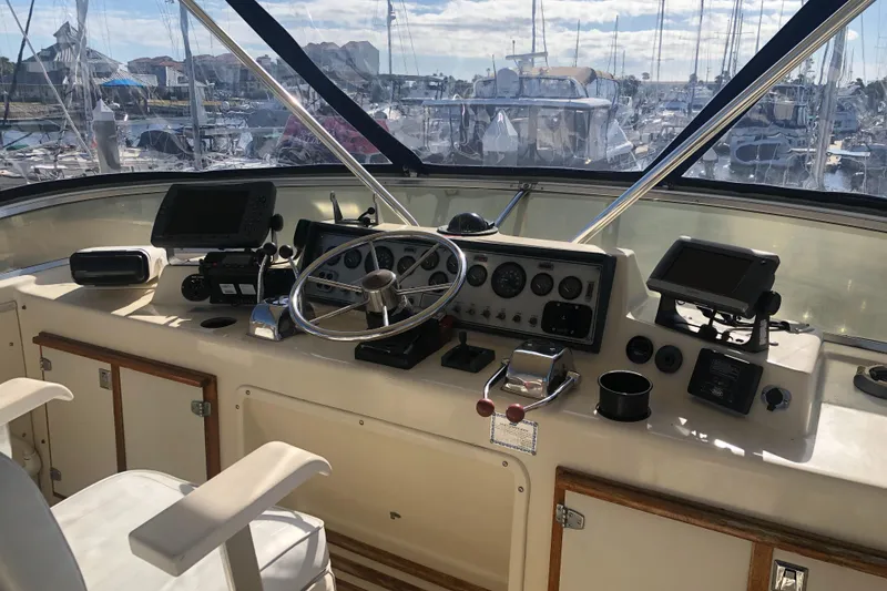 Slide: The Image of 1987 Chris-Craft 426 Catalina helm with navigation equipment and marina view. - 35