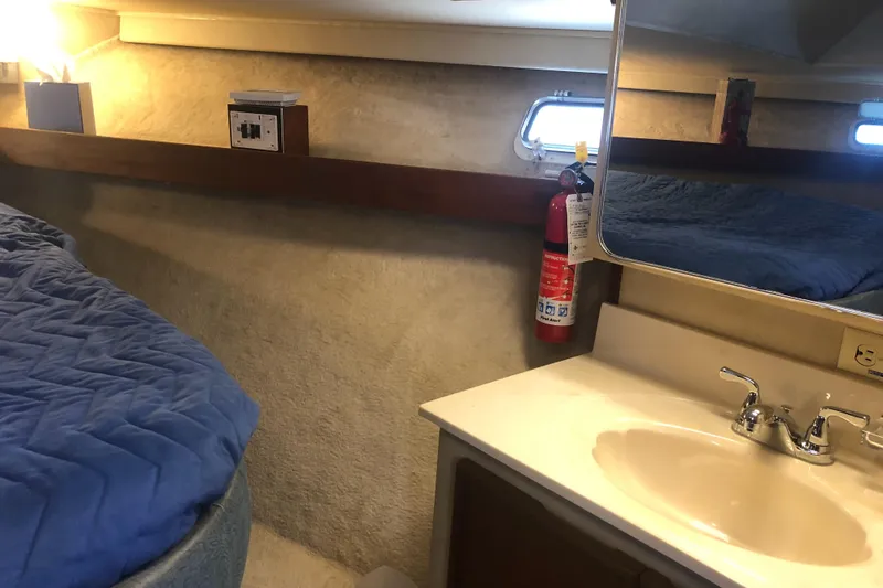 Slide: The Image of 1987 Chris-Craft 426 Catalina cabin interior with sink, mirror, and bed. - 38