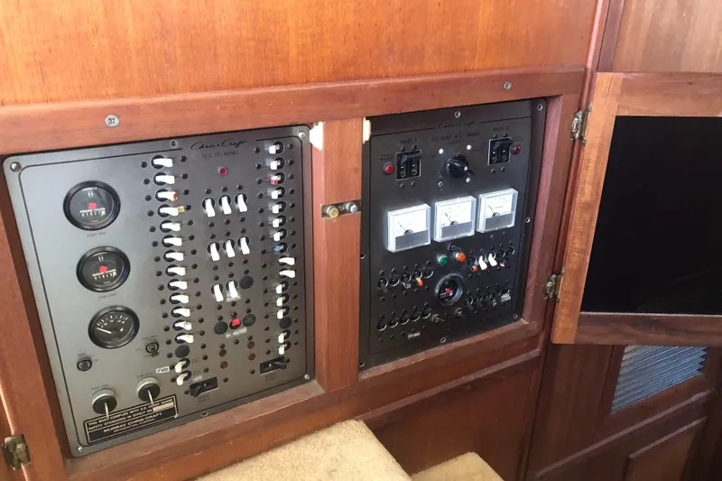 Slide: The Image of 1987 Chris-Craft 426 Catalina control panel with gauges and switches in wooden cabinet. - 40