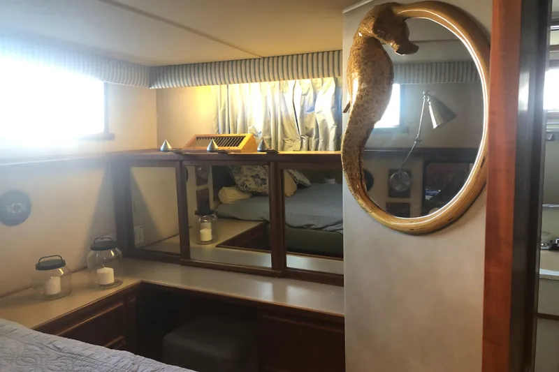 Slide: The Image of Interior of 1987 Chris-Craft 426 Catalina yacht, featuring cozy cabin with decorative seahorse mirror. - 42