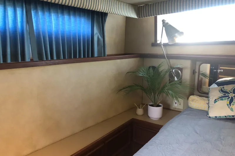 Slide: The Image of Interior of 1987 Chris-Craft 426 Catalina with bed, potted plant, and blue curtains. - 43