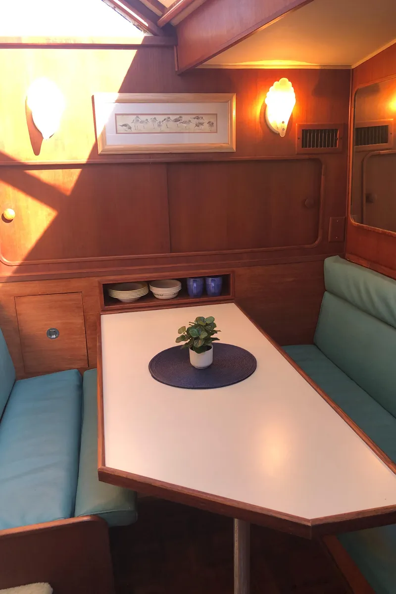 Slide: The Image of 1987 Chris-Craft 426 Catalina interior with dining area, teal seating, and wooden accents. - 8