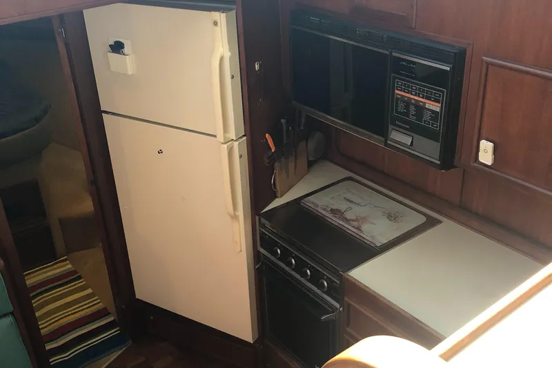 Slide: The Image of 1987 Chris-Craft 426 Catalina kitchen with fridge, stove, and microwave. - 9