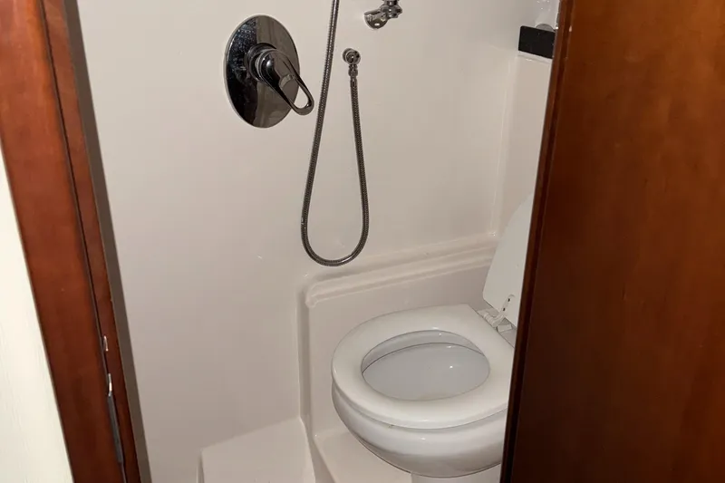 Slide: The Image of Bathroom in 2015 Regal 42 Sport Coupe yacht with toilet and showerhead. - 17