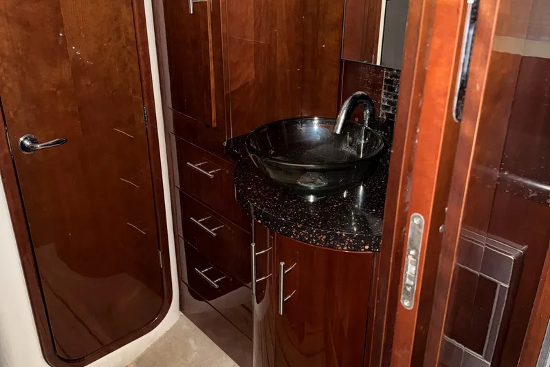 Slide: The Image of Luxurious bathroom in 2015 Regal 42 Sport Coupe with modern sink and wooden cabinetry. - 18