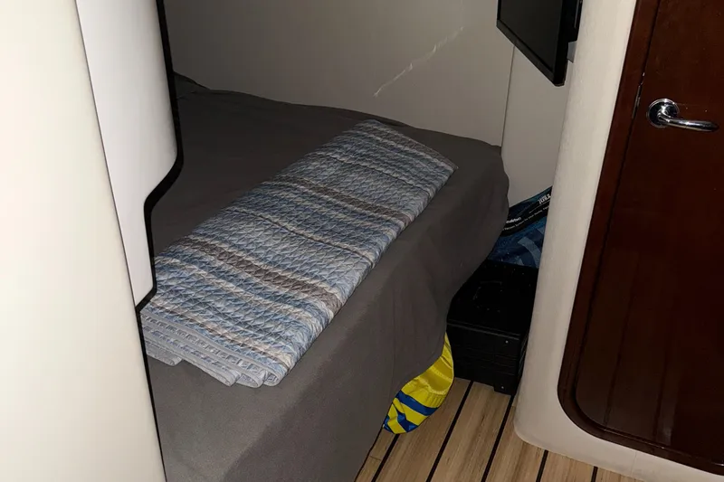 Slide: The Image of 2015 Regal 42 Sport Coupe cabin interior with bed and folded blanket. - 20