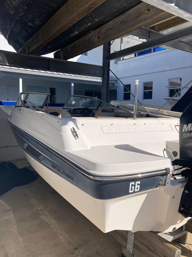 Slide: The Image of 2014 Bayliner 180 Bowrider boat in storage, white exterior, parked indoors. - 12