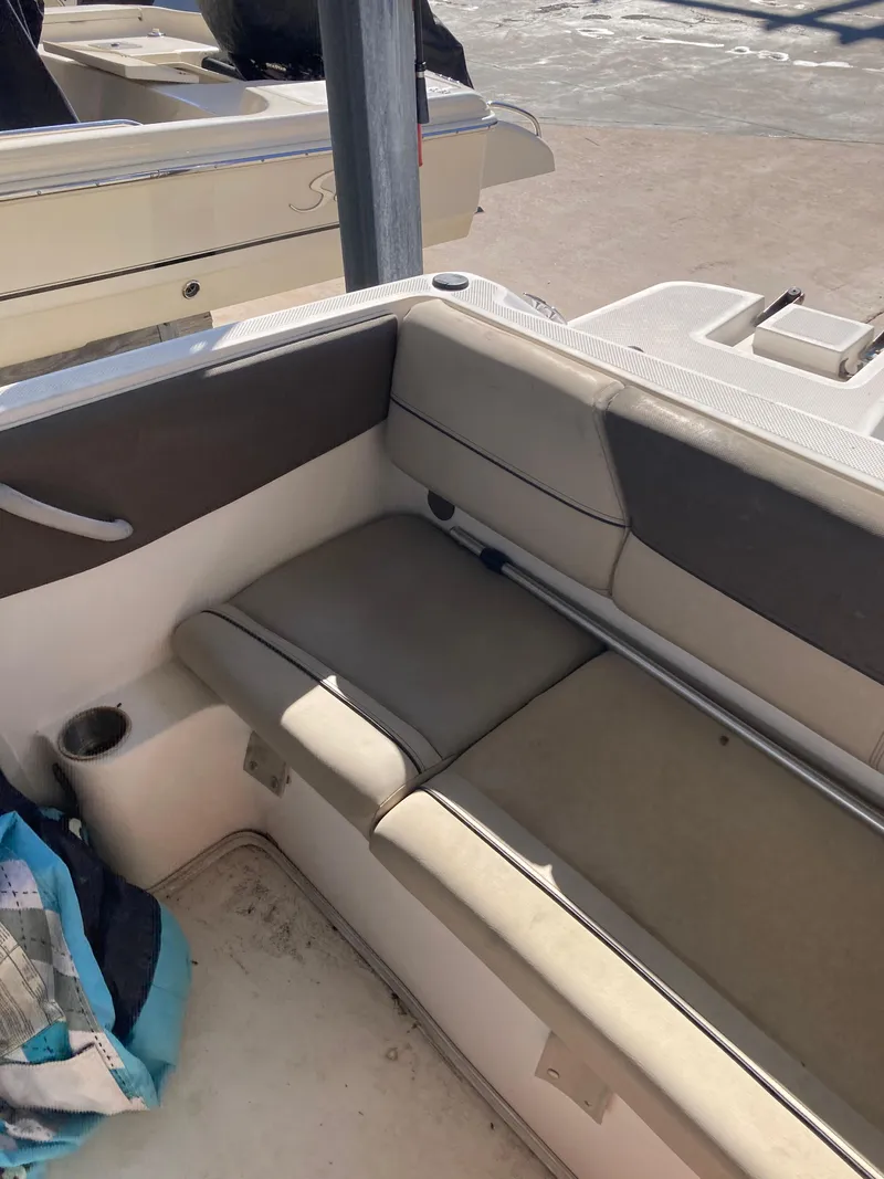 Slide: The Image of 2014 Bayliner 180 Bowrider interior seating with beige and brown upholstery. - 4
