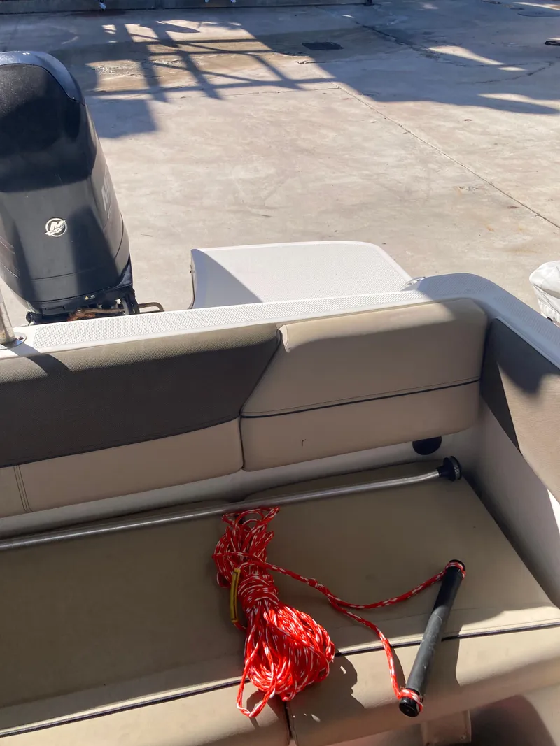 Slide: The Image of 2014 Bayliner 180 Bowrider interior with red rope and motor in view. - 5
